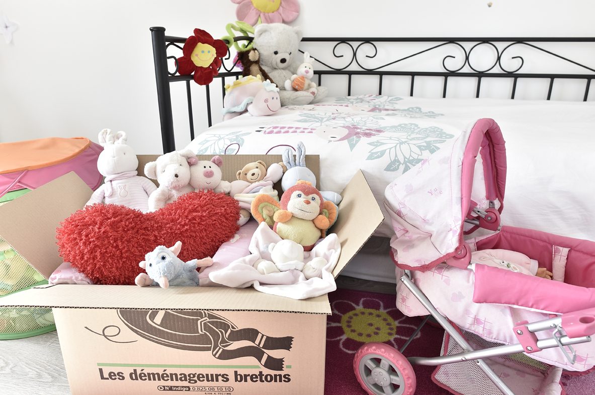 Carton ouvert contenant des affaires personnelles dans une chambre