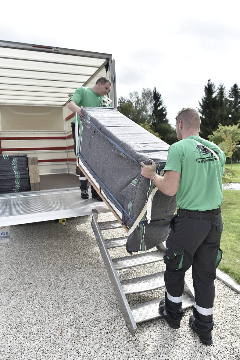 Deux d&eacute;m&eacute;nageurs professionnels chargeant des cartons dans un camion